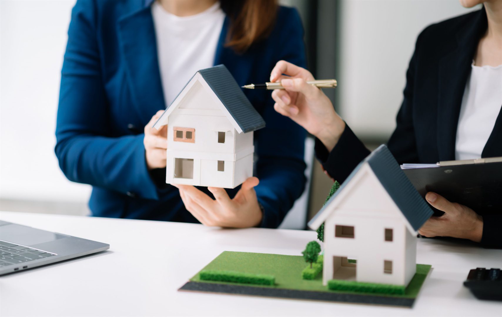 salesman-hands-on-house-model-small-toy-house