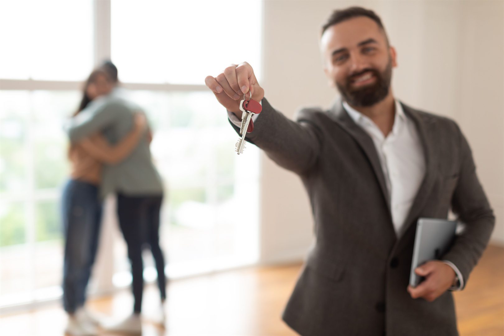smiling-real-estate-agent-holding-and-showing-key