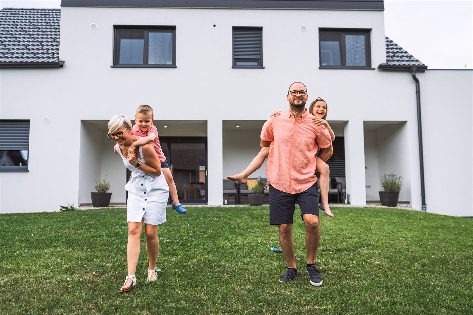 young-family-standing-outside-their-house