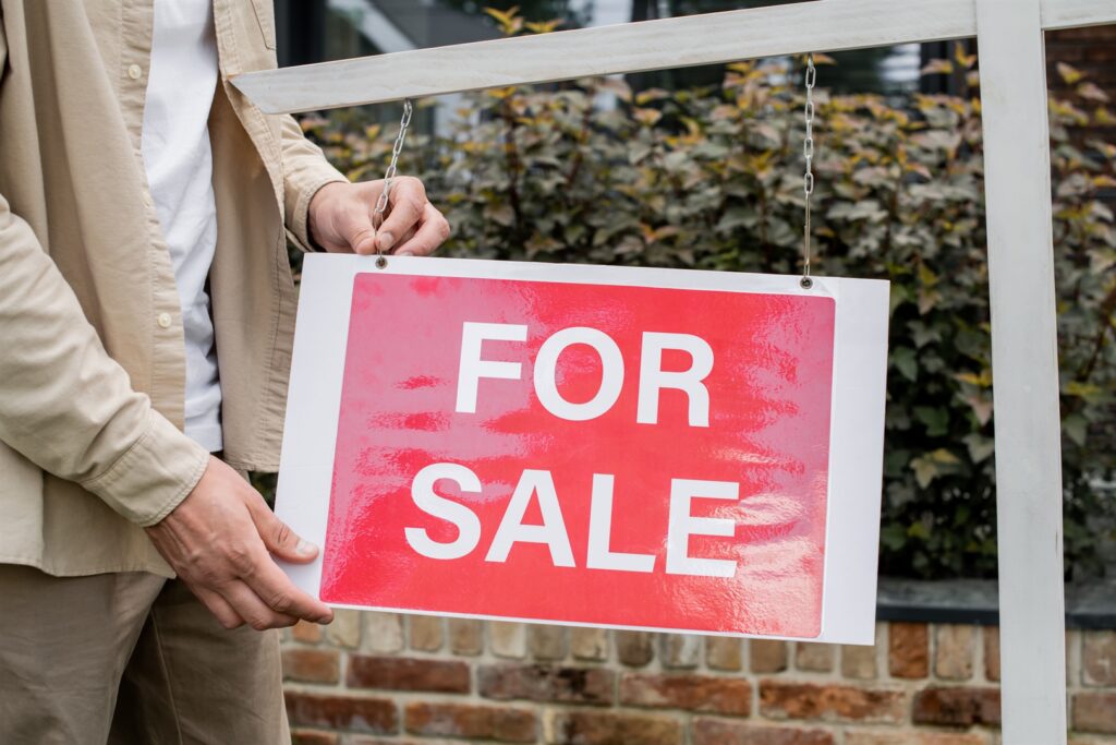 partial-view-of-real-estate-agent-hanging-signboar